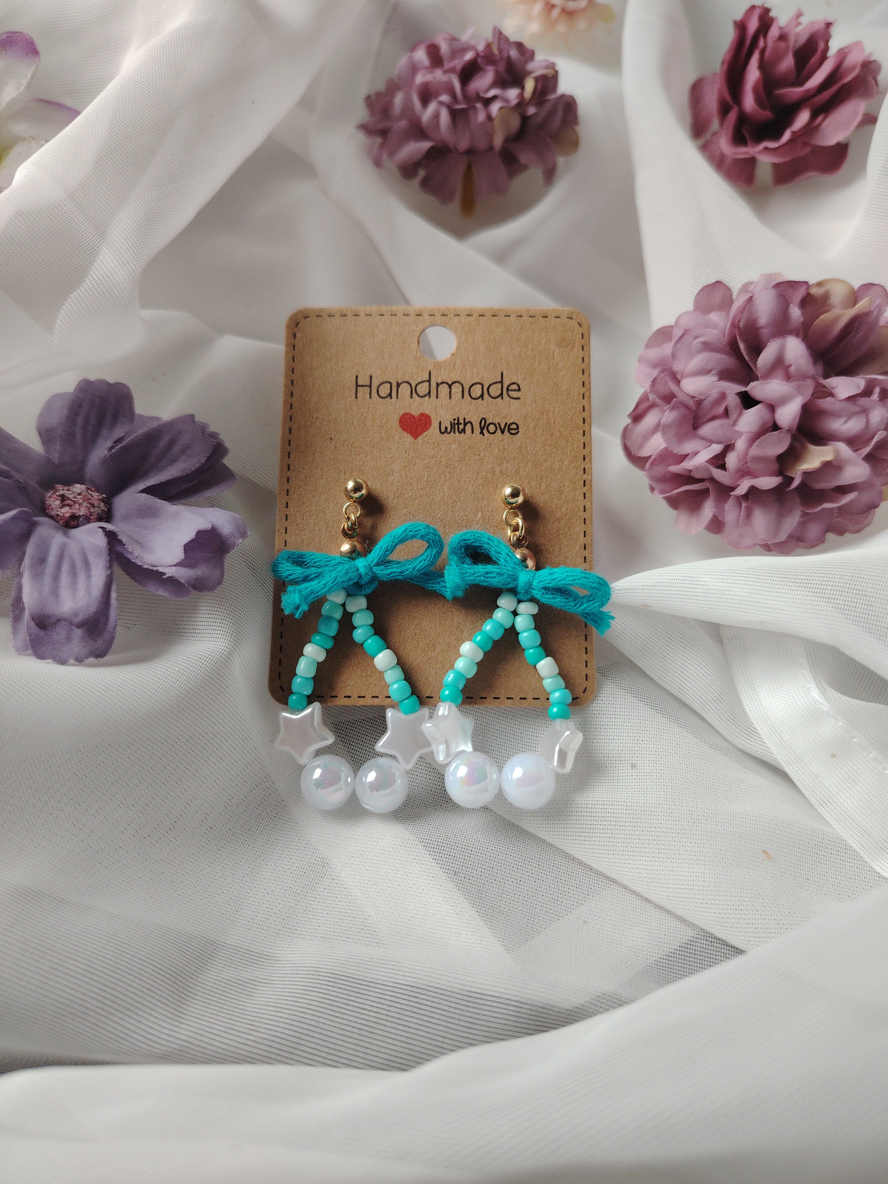 Oorbellen met kleine, grote parels in de kleuren wit, blauw en een speels blauw strikje