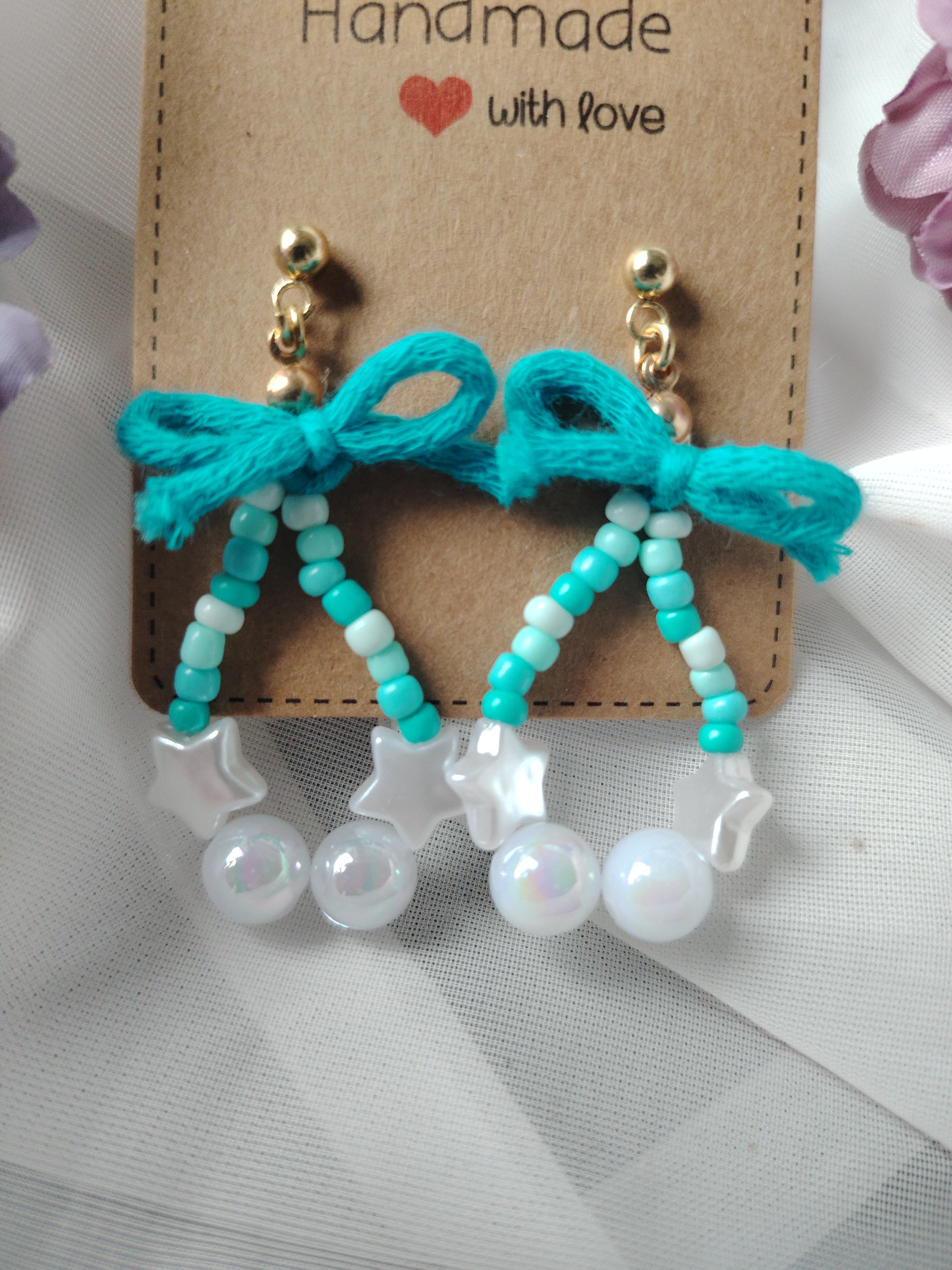 Oorbellen met kleine, grote parels in de kleuren wit, blauw en een speels blauw strikje