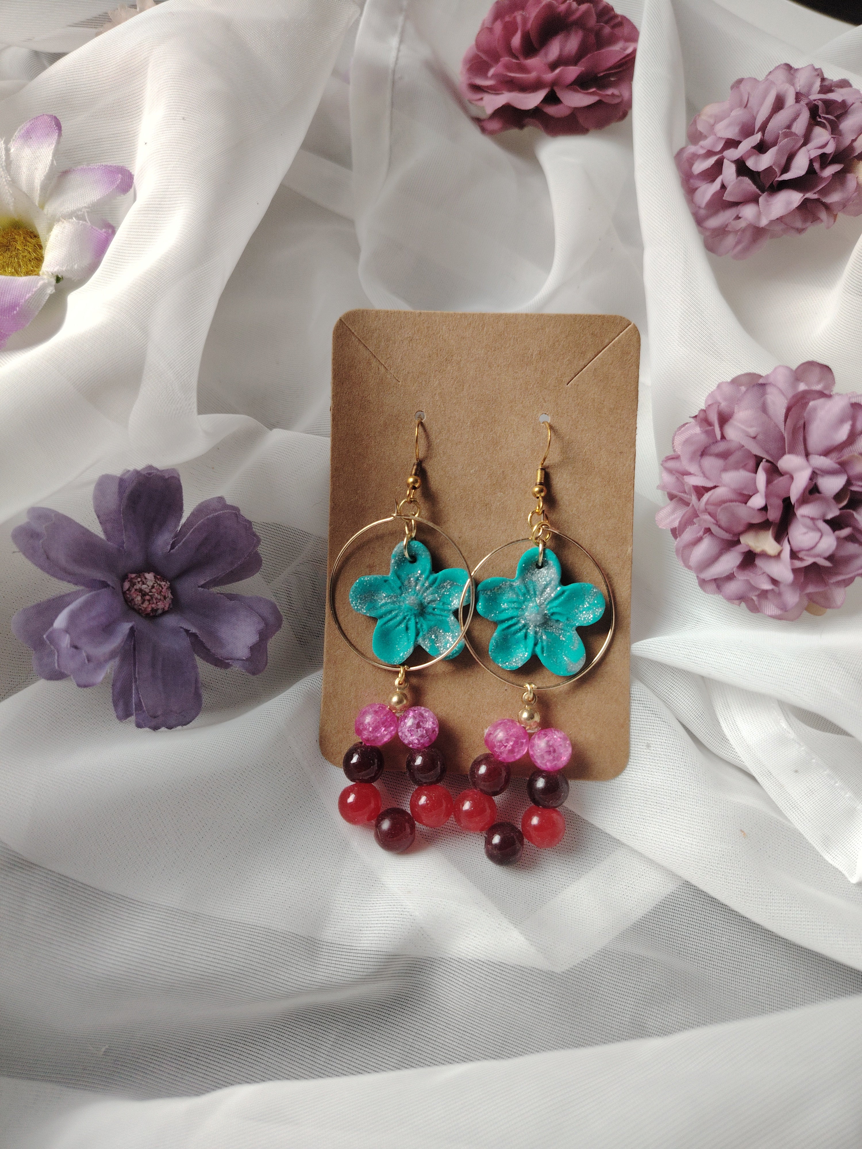 Gouden Creoolse hangers met blauw-glitterende bloemen en mooie glaskralen