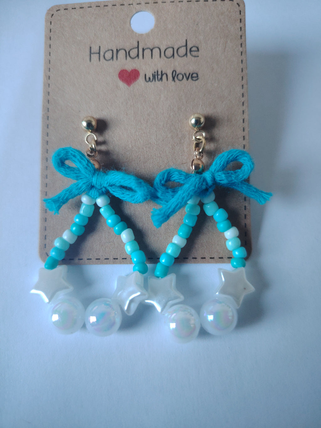 Oorbellen met kleine, grote parels in de kleuren wit, blauw en een speels blauw strikje