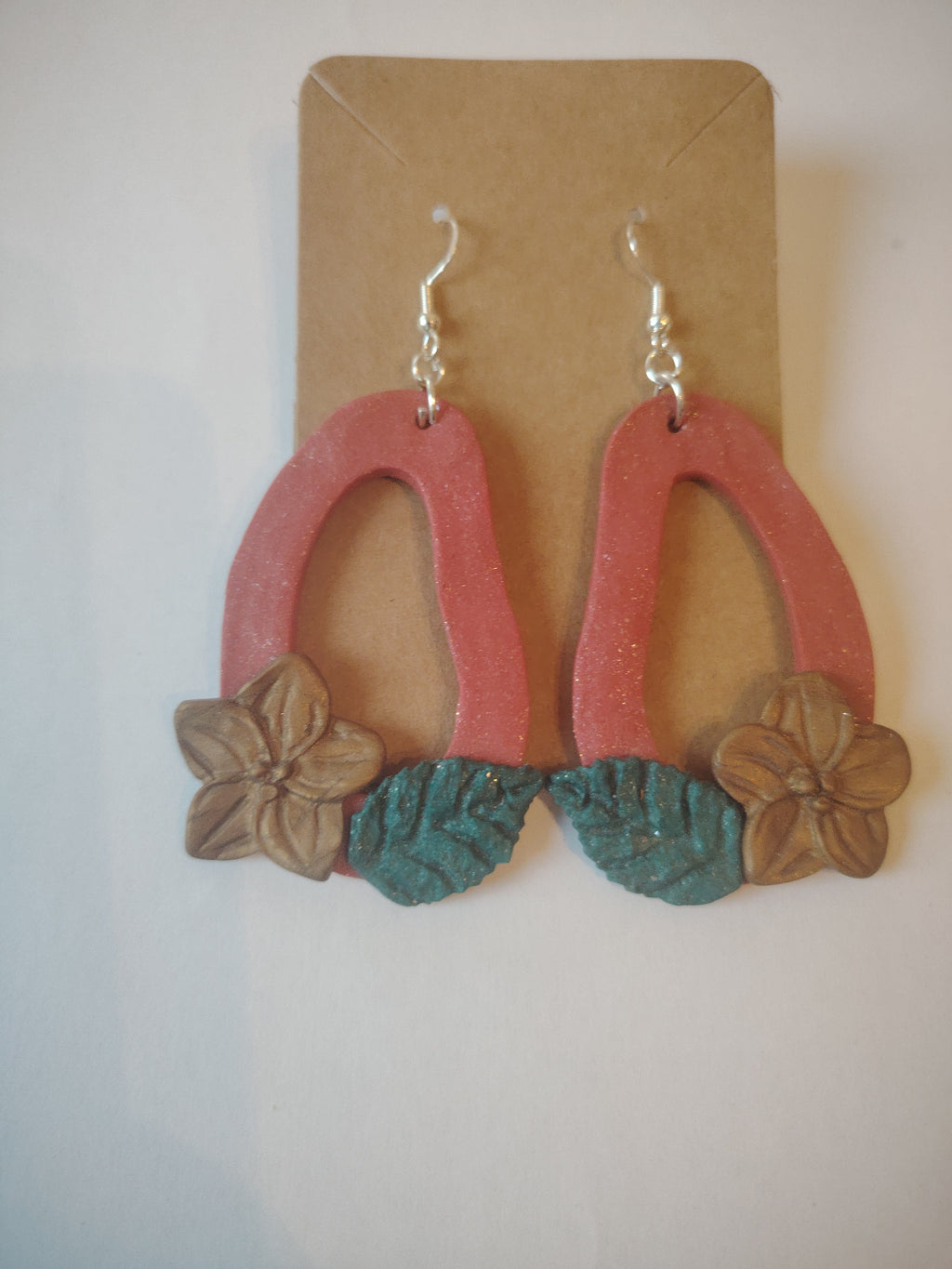 Stylish red earrings with a golden flower and green leaf