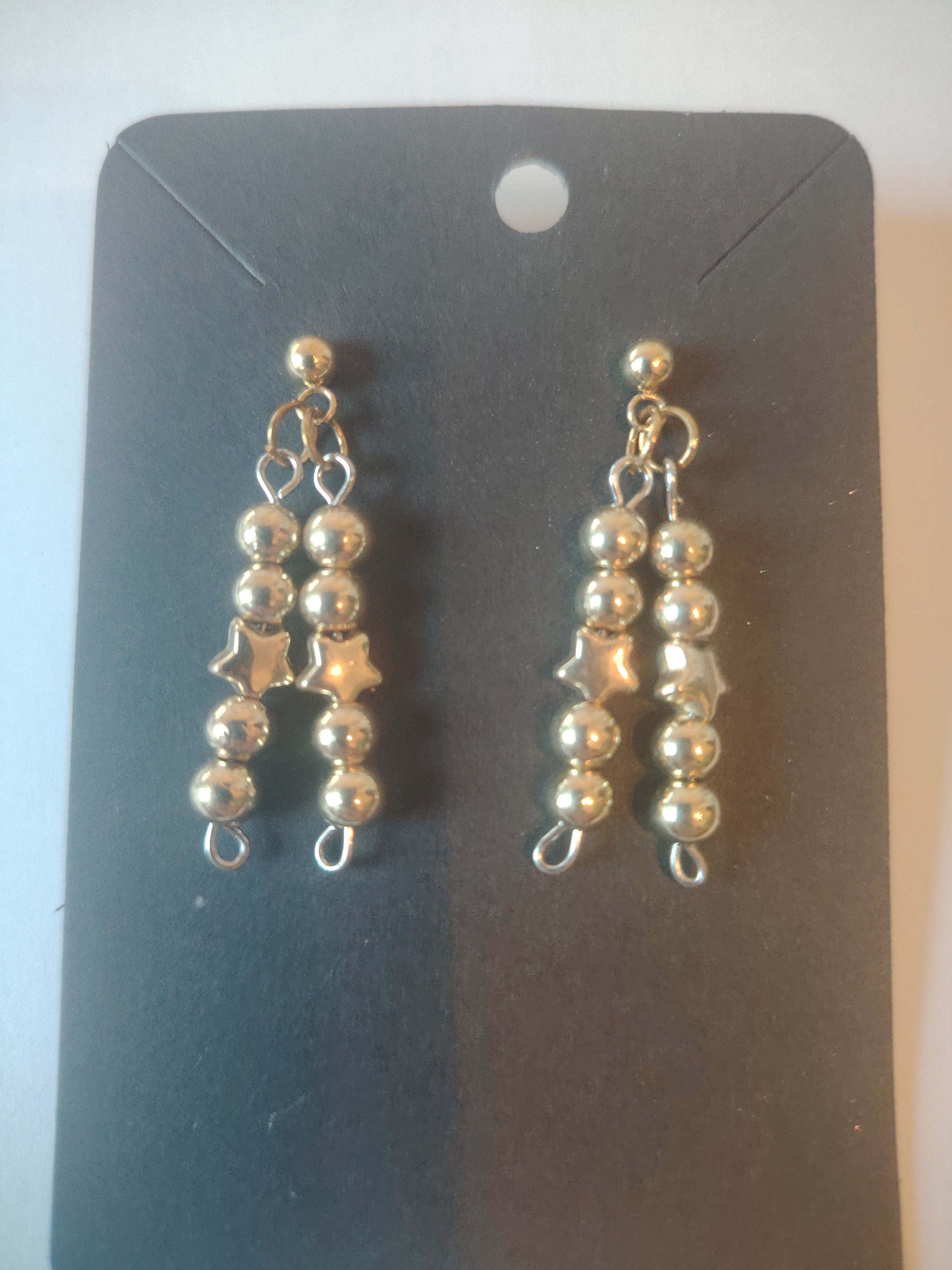 Gouden oorbellen hangers met parels en sterretjes