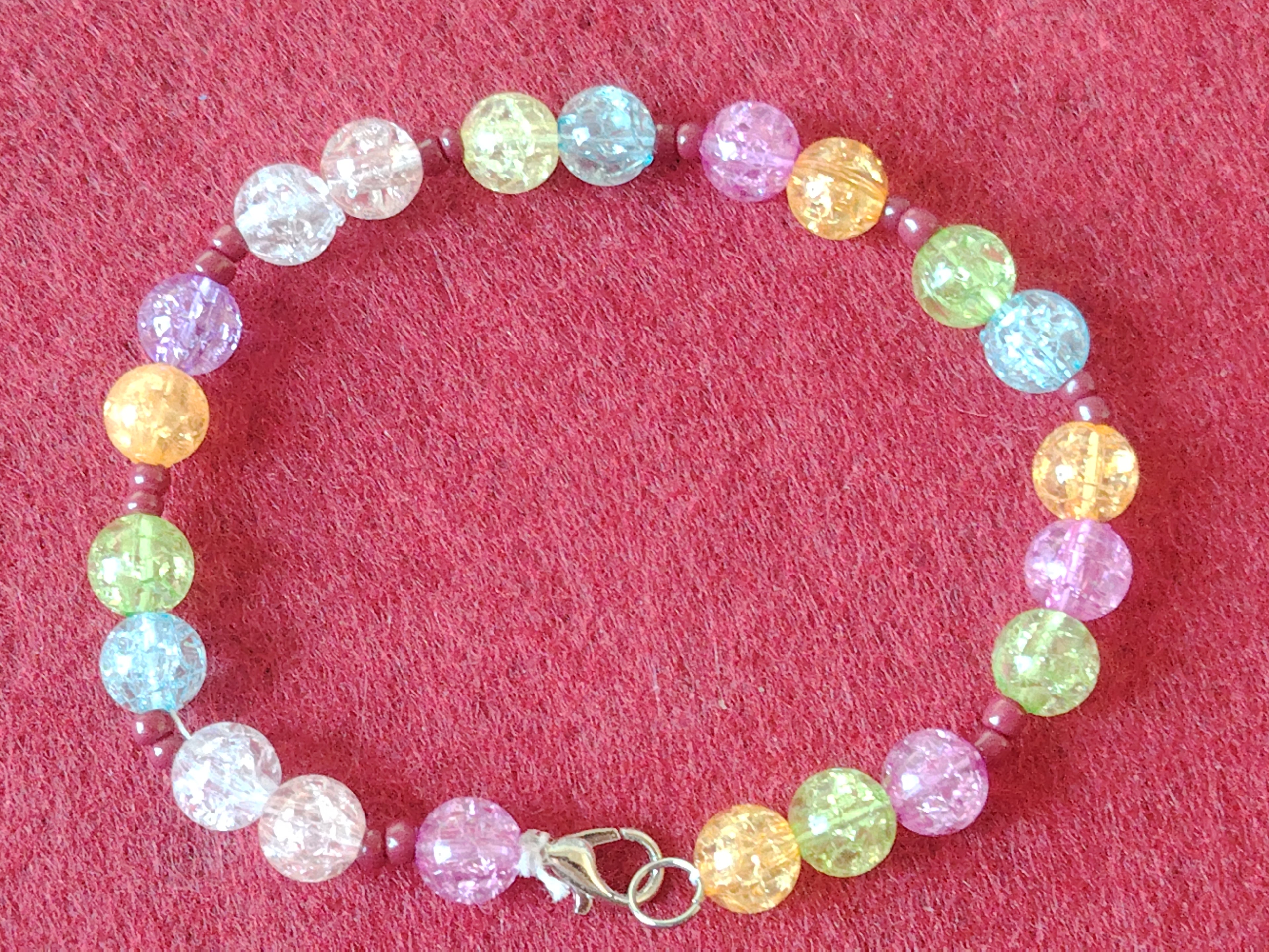 Armband mit Kristall Optik in den Farben Hellem Lila, Hellem Blau, Gelb, kleine Rote Perlen